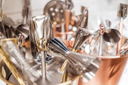 Metal parts being electroplated in an industrial plating tank with visible electrical connections